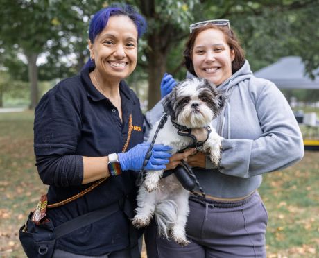 ASPCA community medicine employee standing with community member, holding puppy